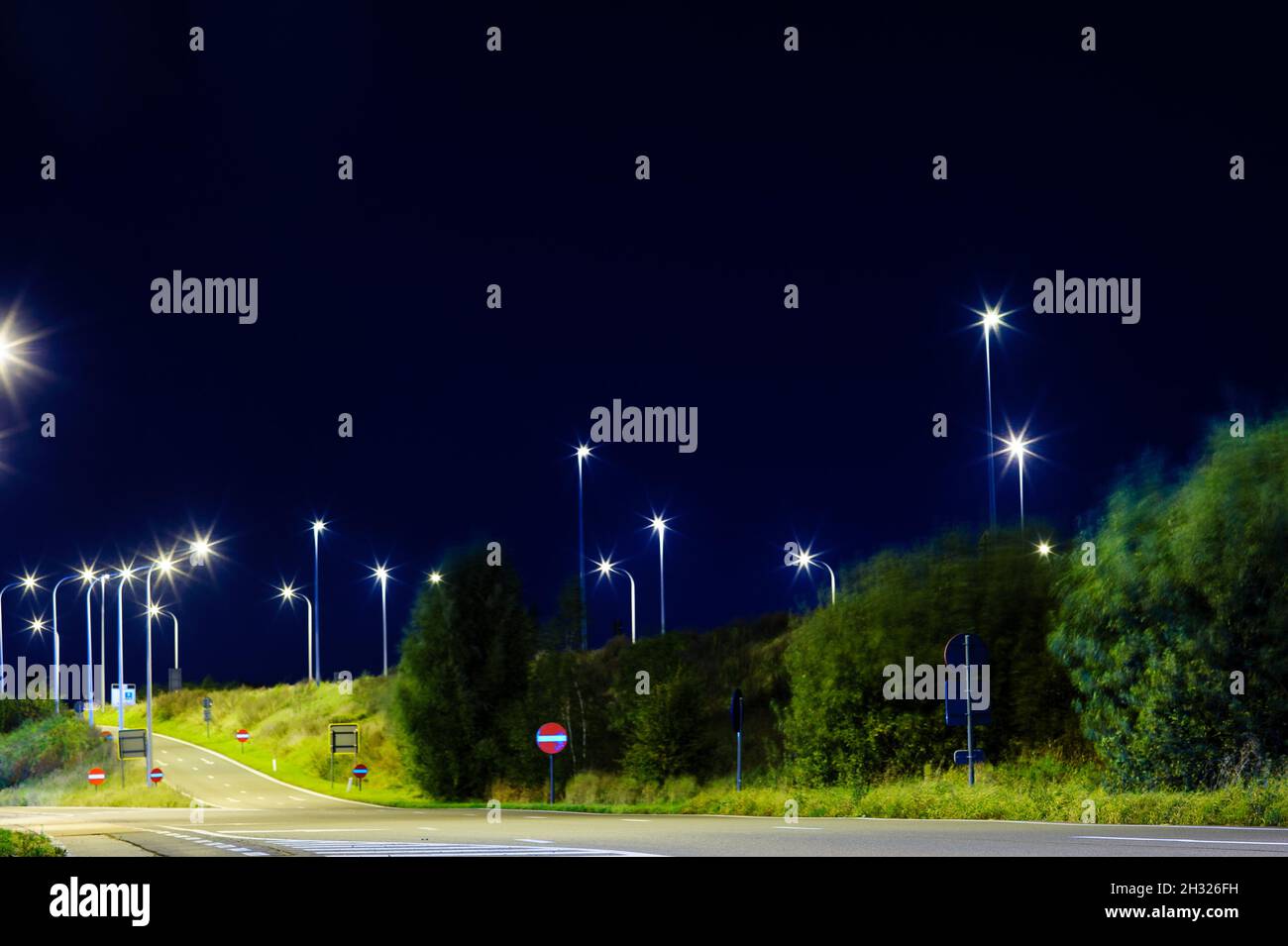 Lowangle Blick auf eine Autobahn in der Nacht mit brennenden Lichtern Stockfoto