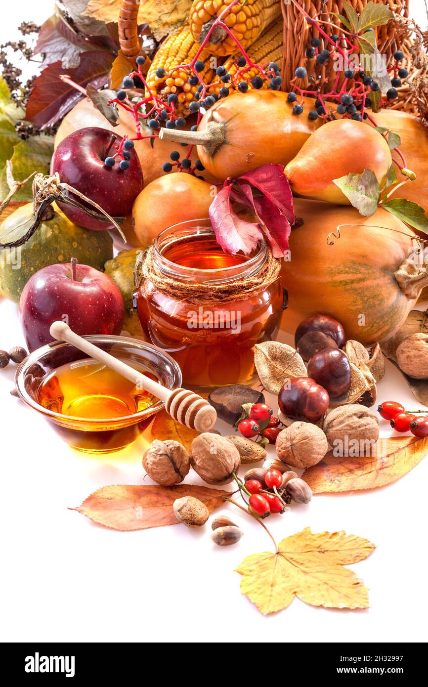 Honig, Äpfel und Herbstfrüchte auf weißem Hintergrund Stockfoto