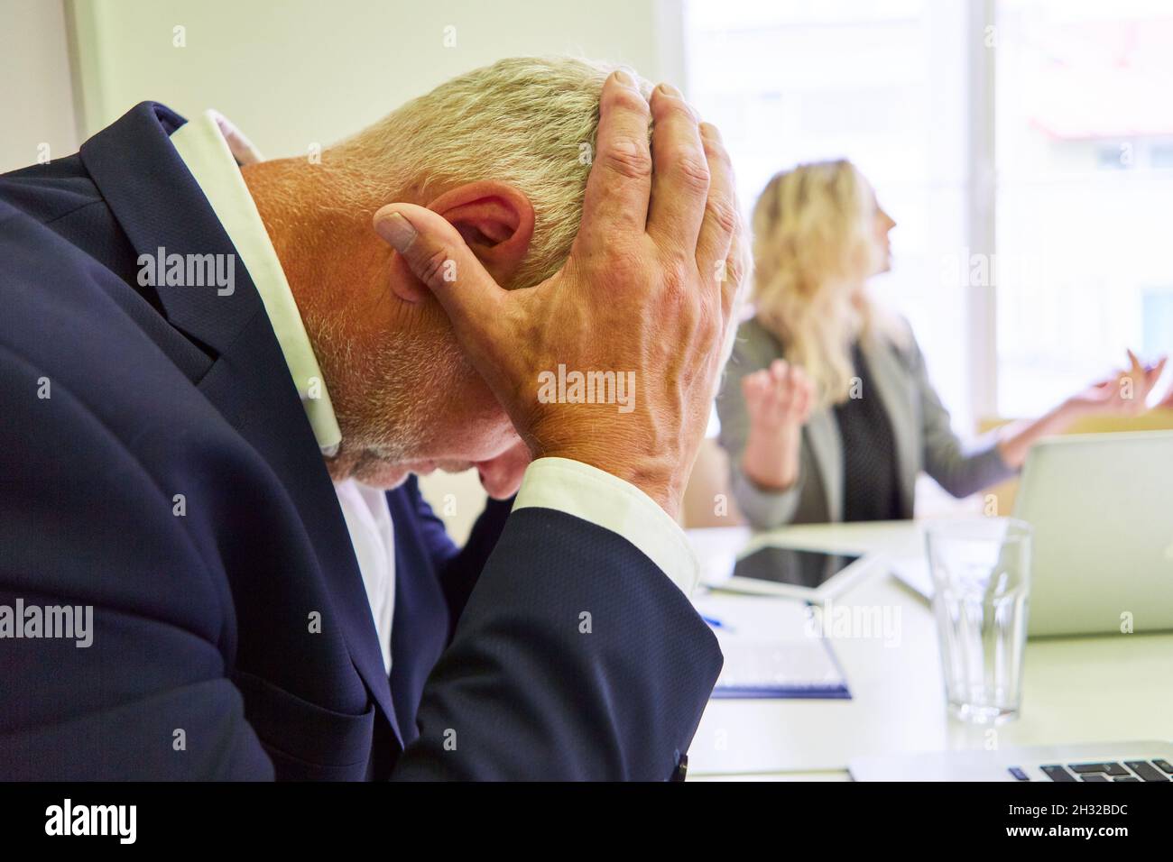 Geschäftsmann mit Händen am Kopf für Burnout oder Verzweiflung wegen Bankrott Stockfoto