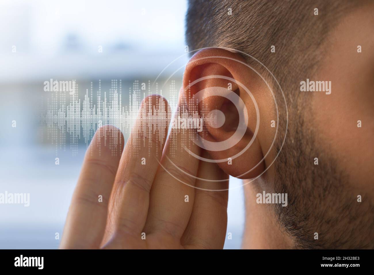 Junger Mann mit Hörproblemen oder Hörverlust. Hörtestkonzept. Stockfoto