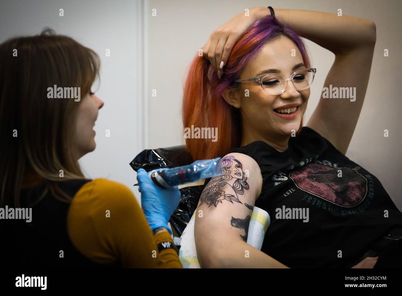 Warschau, Polen. Okt. 2021. Eine Tätowiererin arbeitet am Arm einer Frau während der 8. Warsaw Tattoo Convention in Warschau, Polen, am 24. Oktober 2021. Quelle: Str/Xinhua/Alamy Live News Stockfoto