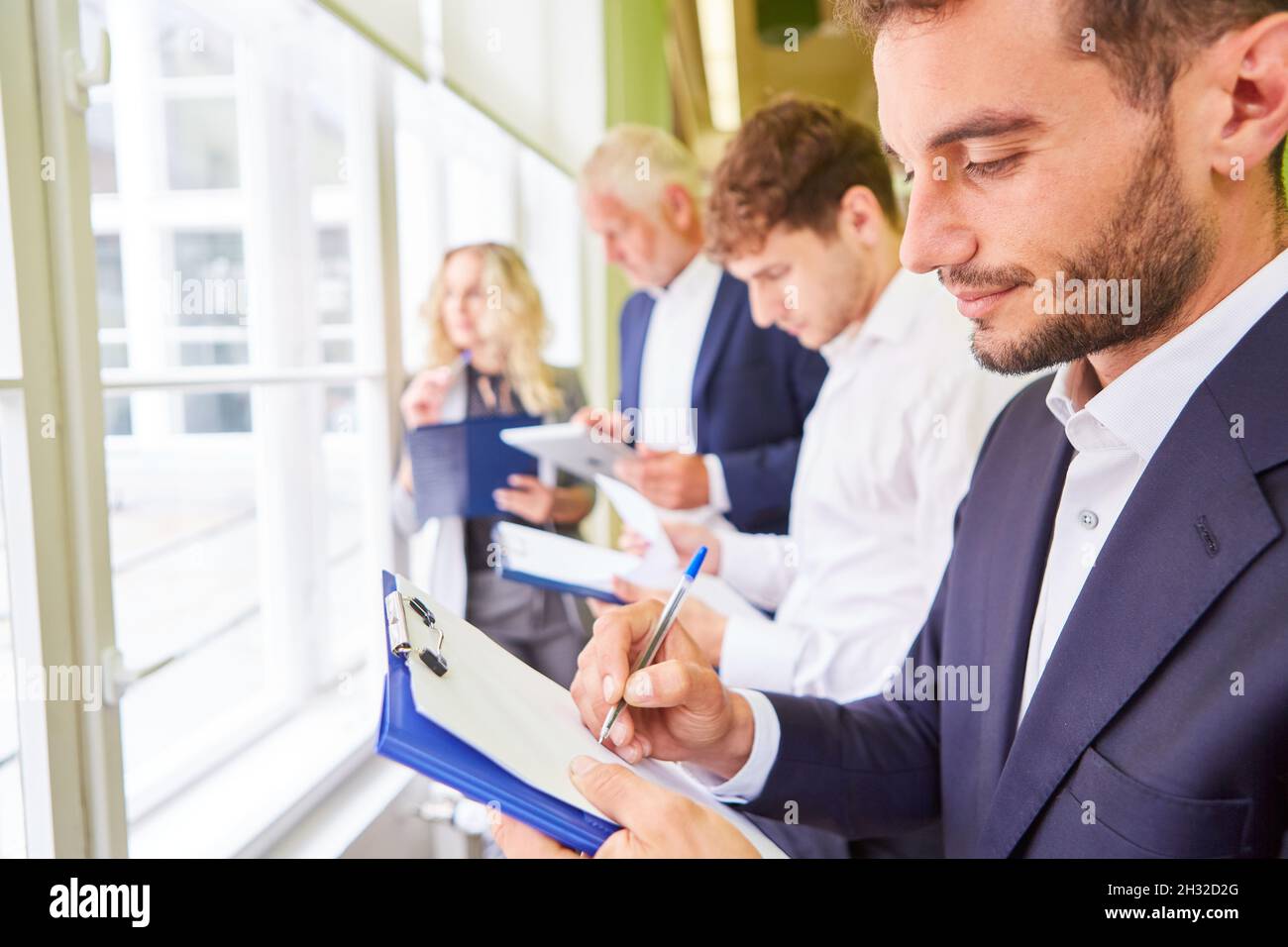 Mitarbeiter des Geschäftsteams mit Clipboard, die Ideen in einem Brainstorming-Workshop niederschlagen Stockfoto