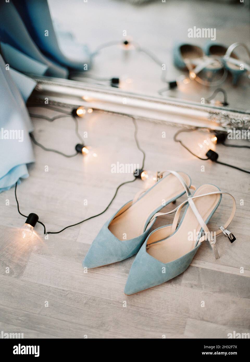 Blaue Wildleder hohe Absatz Sommer weibliche Schuhe und Lampen Girlande auf  einem Boden, mit Spiegel Hintergrund, moderne Mode. Draufsicht, flach  liegend, Nahaufnahme Stockfotografie - Alamy