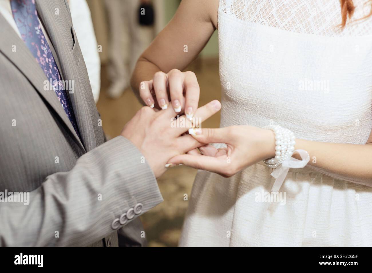 Hochzeitszeremonie. Austausch Von Eheringen. Die Braut zieht den goldenen Ehering an, um den Finger des Bräutigams aus der Nähe zu berühren. Braut und Bräutigam, Brautpaar. Stockfoto
