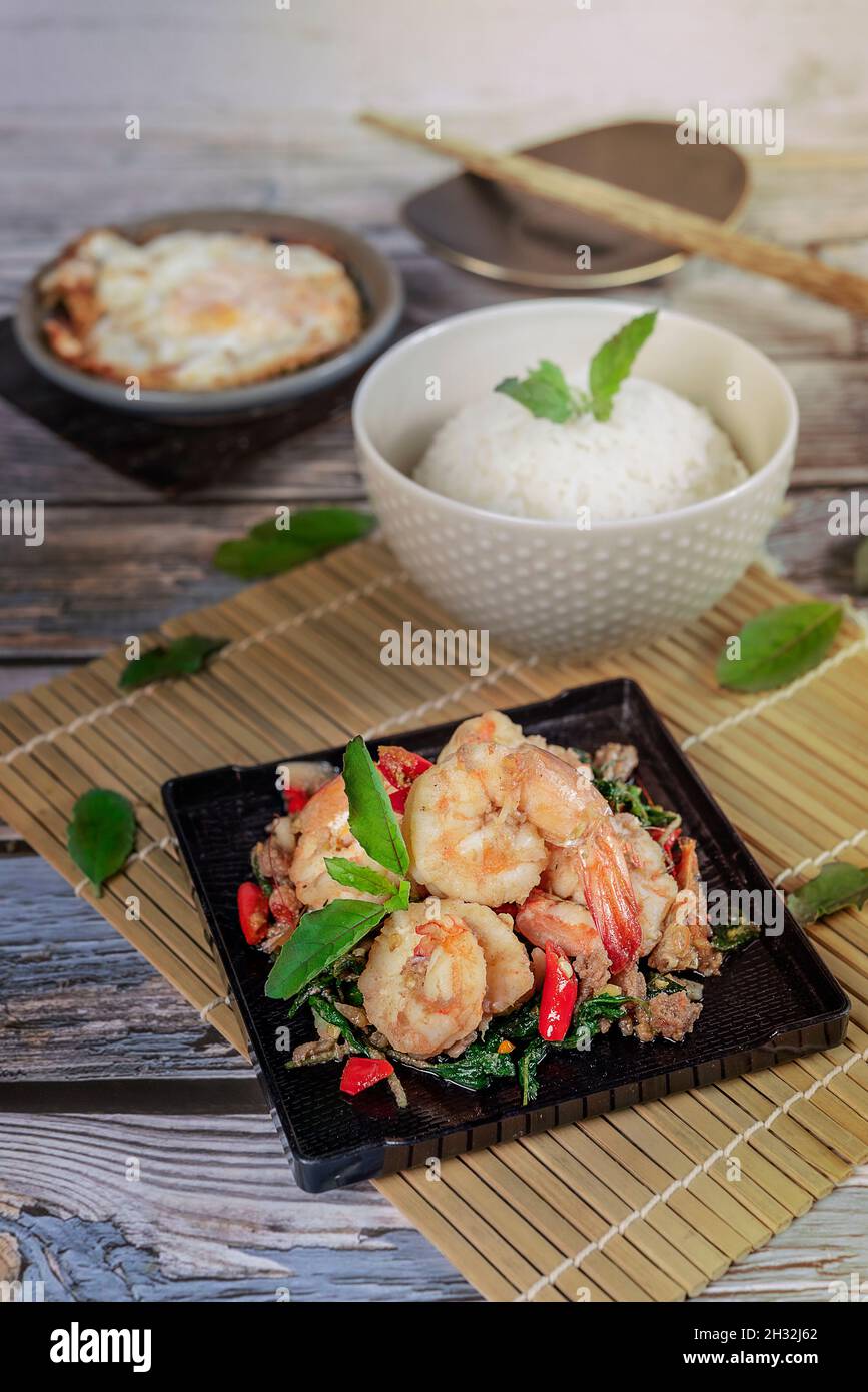 Gebratenes Kräutergemüse mit Garnelen, serviert mit gedämpftem Reis und Spiegeleiern Stockfoto
