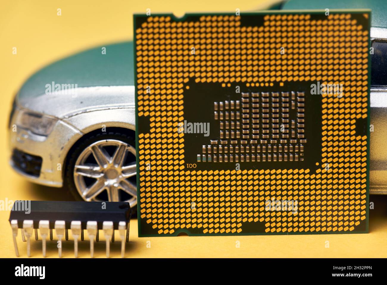 CPU-Chip und Halbleiter mit Autospielzeug. Weltweiter Mangel an Kfz-Chips. Der Mangel an Mikrochips verursacht Mangel an Neuwagen. Computerchip Mangel Stallungen Auto Stockfoto