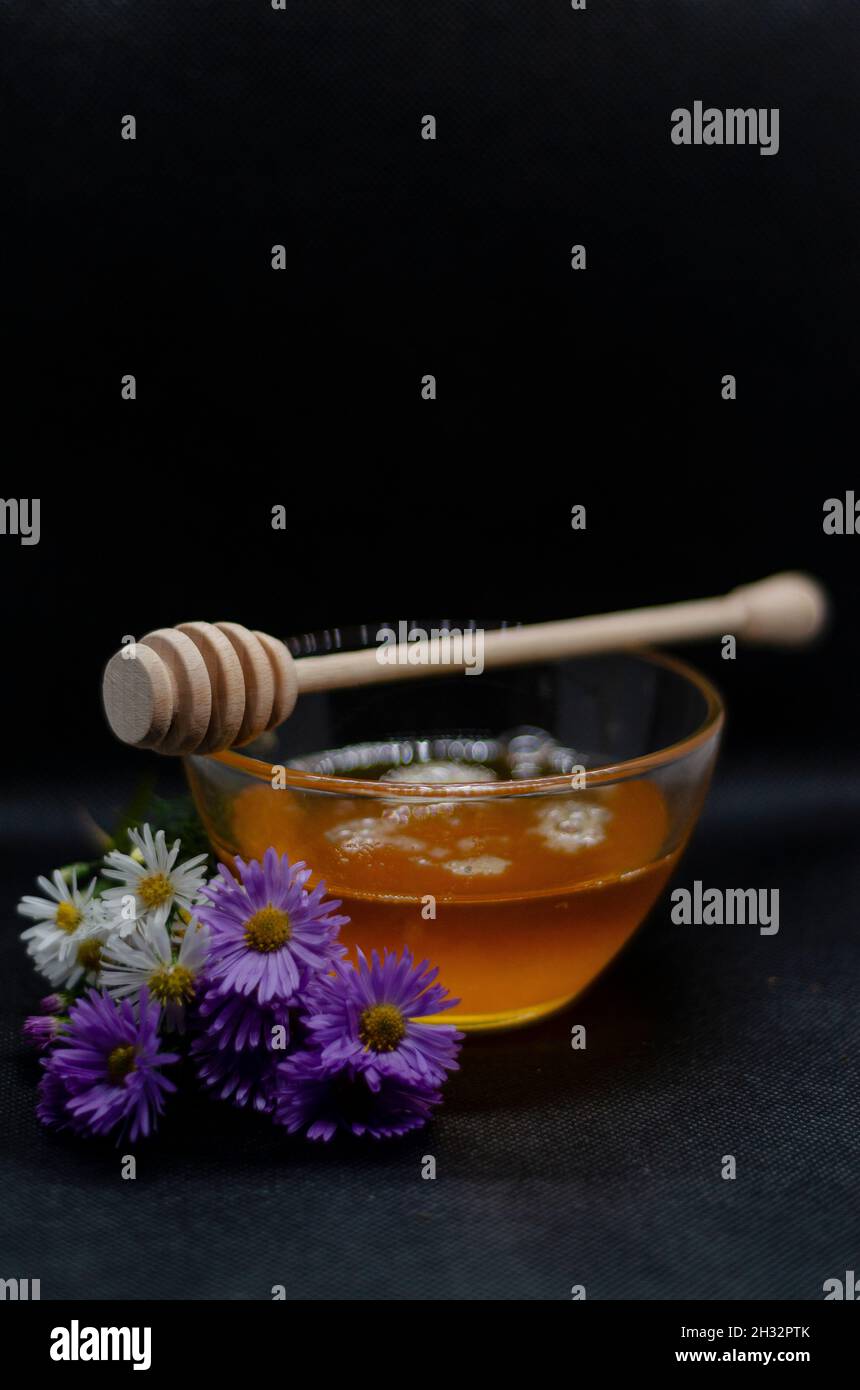 Honig in einer Vase, Fliederblüten und ein Honigtauchmittel Stockfoto