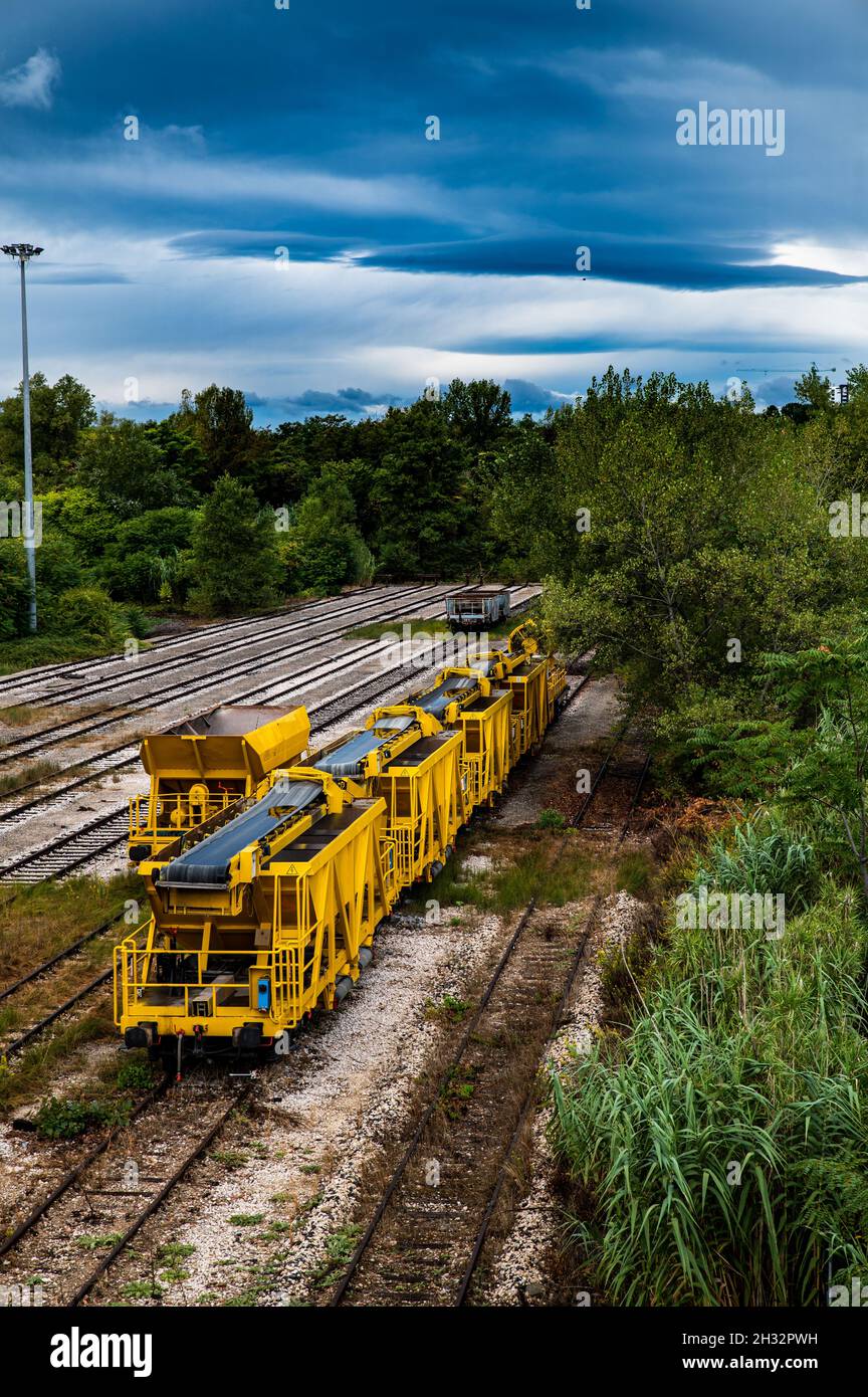 Landschaft mit gelbem Güterzug stationär Stockfoto