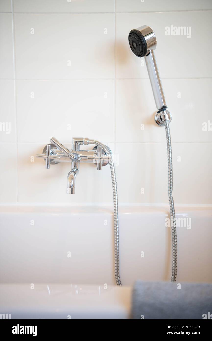 Ein Duschkopf und ein Wasserhahn einer Badewanne Stockfoto