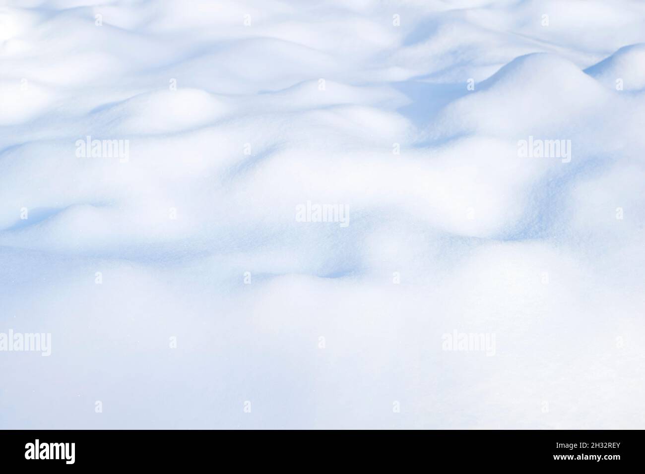 Sonniger Winter weißer Schnee Hintergrund mit blauen Schattierungen von Drifts Stockfoto