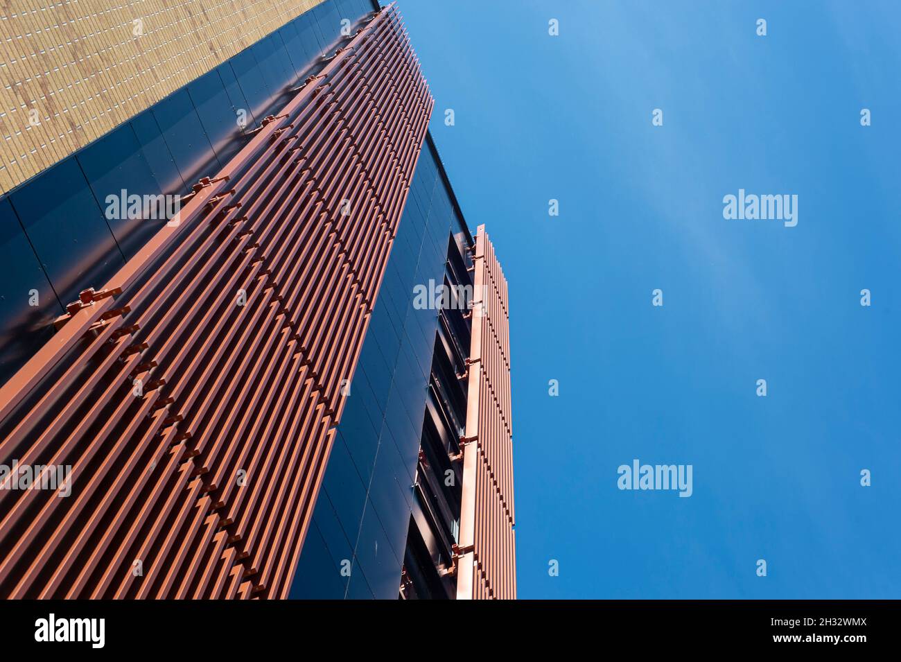 Das moderne Äußere eines Bürogebäudes mit Metallschiebejalousien, die die Sonne ablenken. Stockfoto