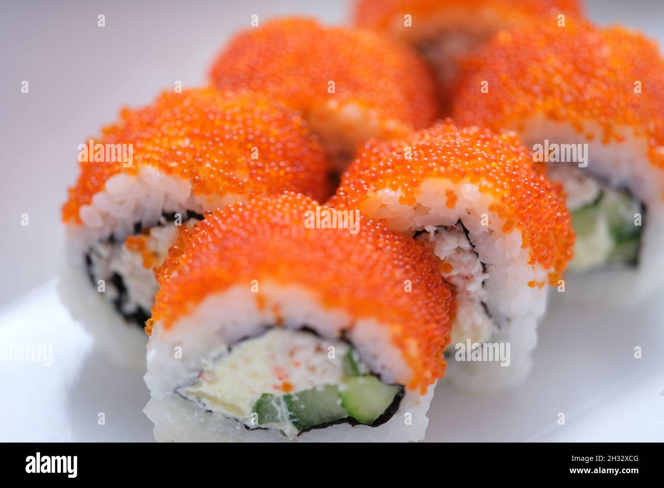 Helles, leckeres Sushi mit Kaviar auf weißer Oberfläche Stockfoto