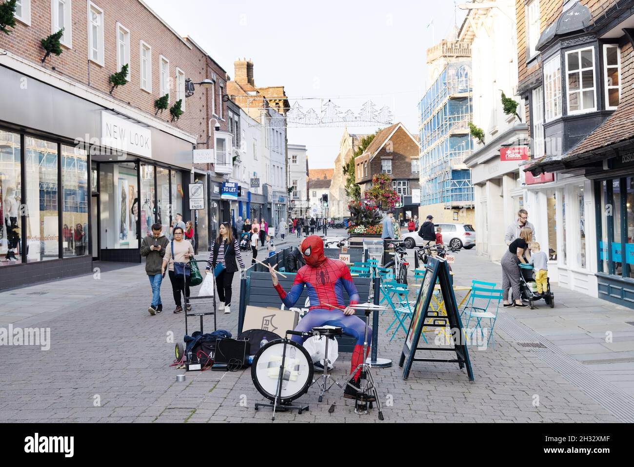 Street Entertainer UK; Ein Straßenmusiker in Spiderman-Kostüm und Schlagzeug, Salisbury City Centre, Salisbury Wiltshire UK Stockfoto