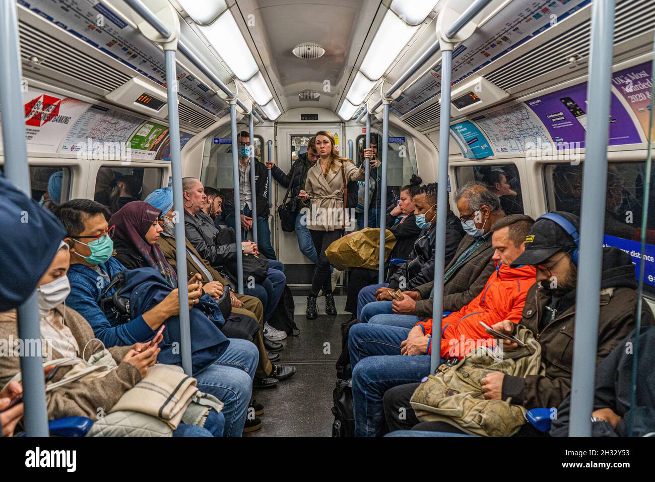 LONDON, GROSSBRITANNIEN. 25 Oktober 2021. Pendler, die während der Hauptverkehrszeit in der Londoner U-Bahn unterwegs sind, während Regierungsminister die Öffentlichkeit dazu drängen, Gesichtsmasken zu tragen, und härtere Beschränkungen könnten diesen Winter zurückkehren, wenn die Infektionsraten weiter steigen. Kredit: amer ghazzal/Alamy Live Nachrichten Stockfoto