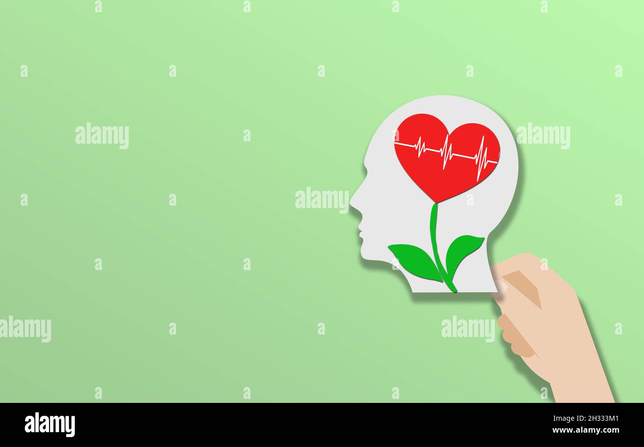 Menschliches Gehirn mit Herzpflanze auf grünem Hintergrund. Welttag Der Psychischen Gesundheit. Kopf hält Mann Kopf mit rotem Herz und Pflanze. Speicherplatz Kopieren Stockfoto