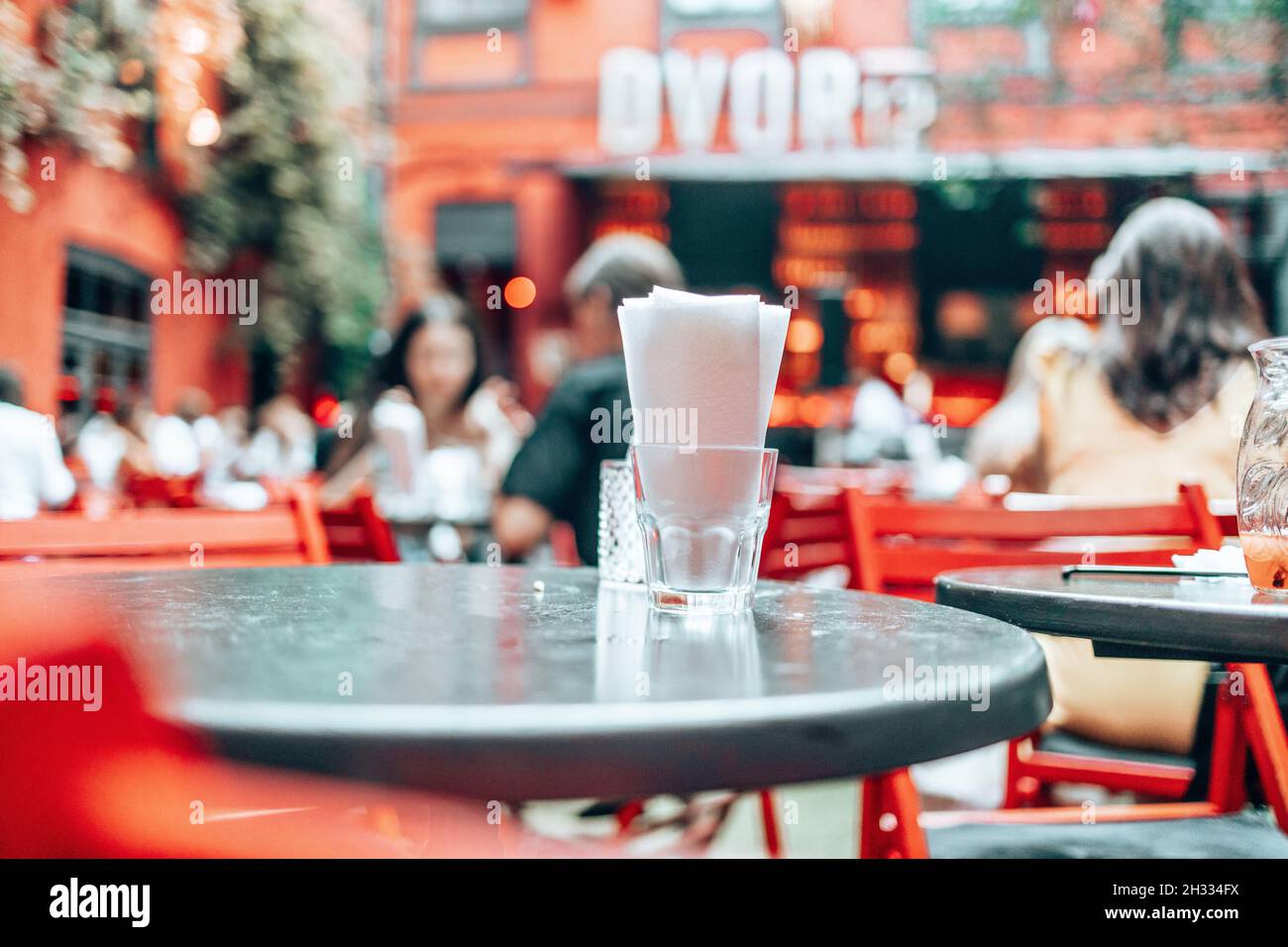 Leerer runder schwarzer Tisch mit City Cafe Restaurant verwischen Hintergrund. Stockfoto