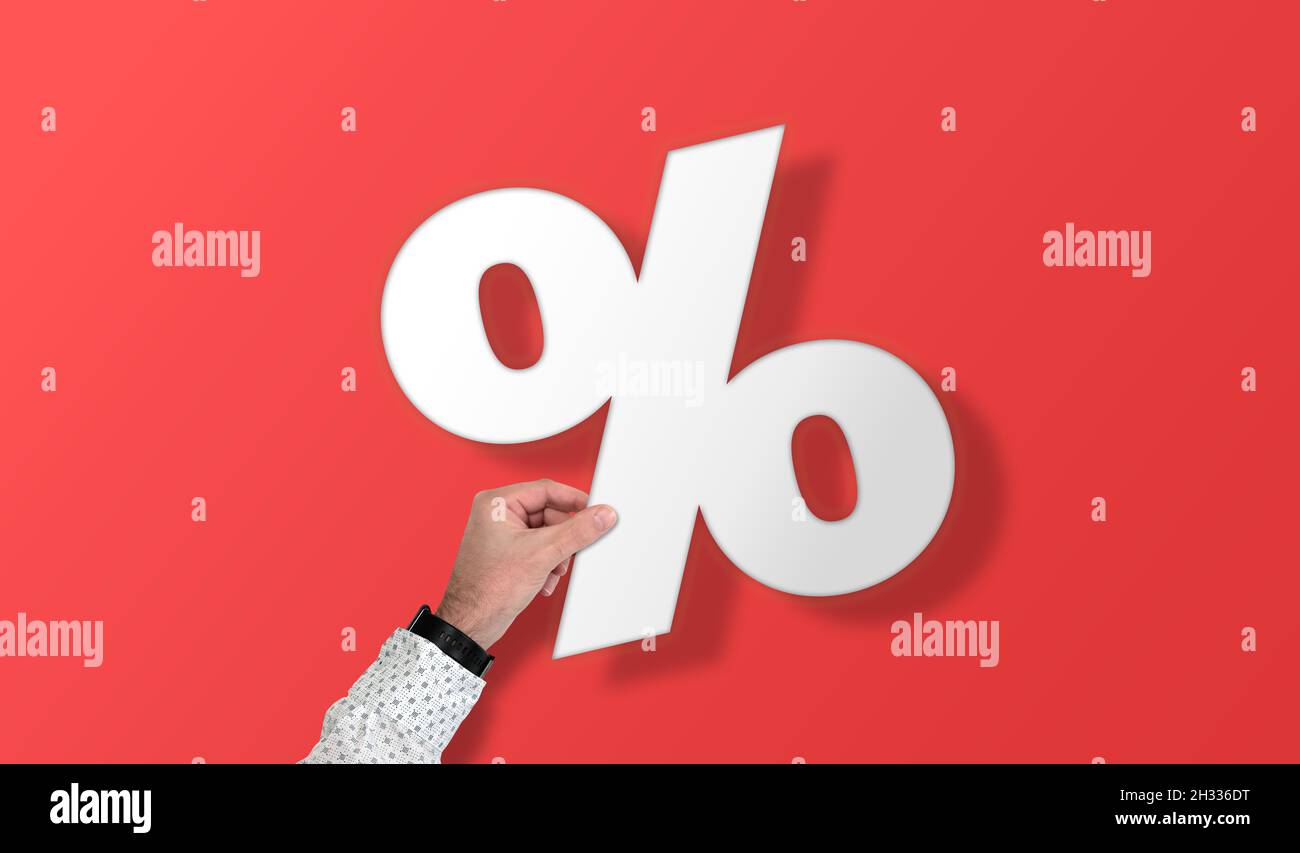 Hand mit großem Prozentzeichen vor rotem Hintergrund, Rabatt und Verkaufskonzept Stockfoto