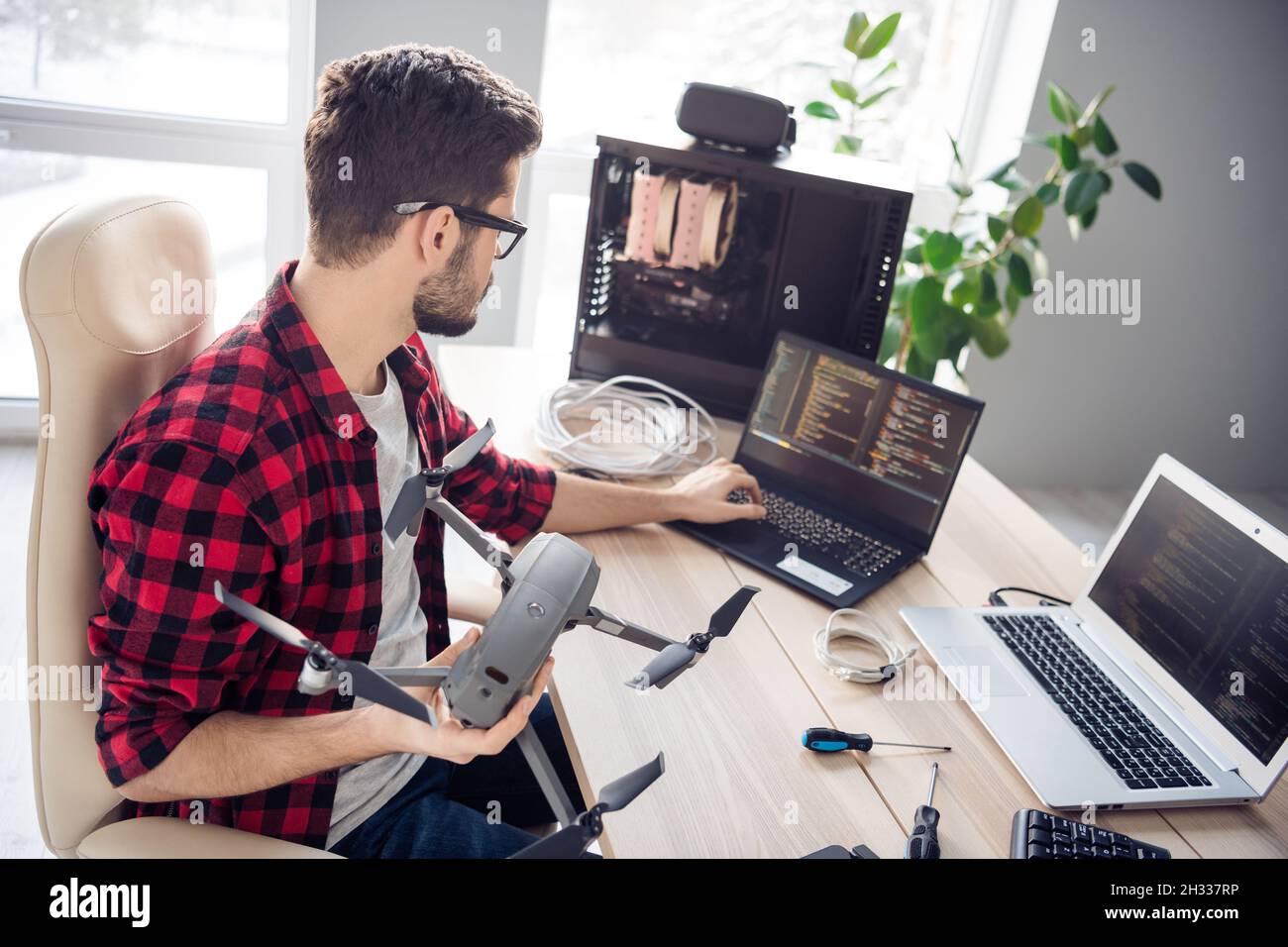 Profil Seitenansicht Porträt von attraktiven smart fokussierten Kerl Fixierung Drohne schreiben Code-Programmierung am Arbeitsplatz Station in Innenräumen Stockfoto