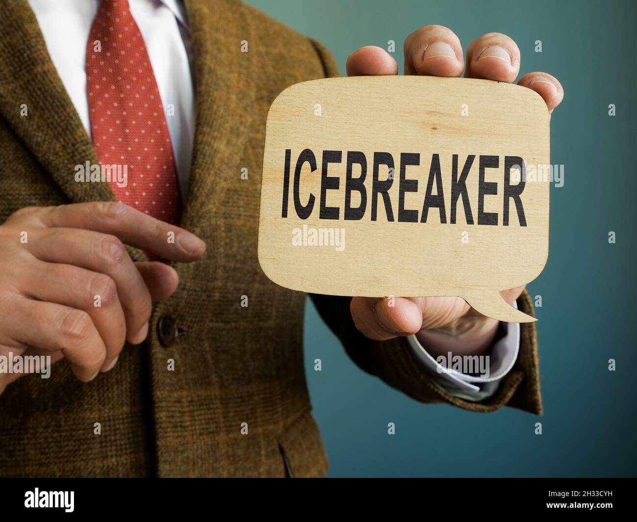Mann im Anzug zeigt Icebreaker-Schild auf dem Teller. Stockfoto