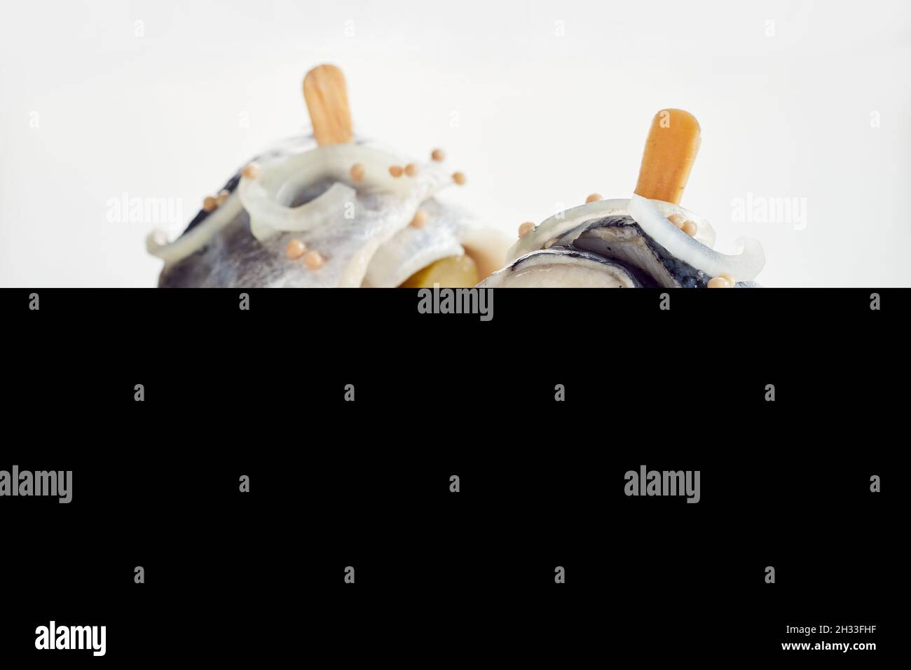 Nahaufnahme von Rollmops aus Heringsfilet und eingelegten Gurken mit ...