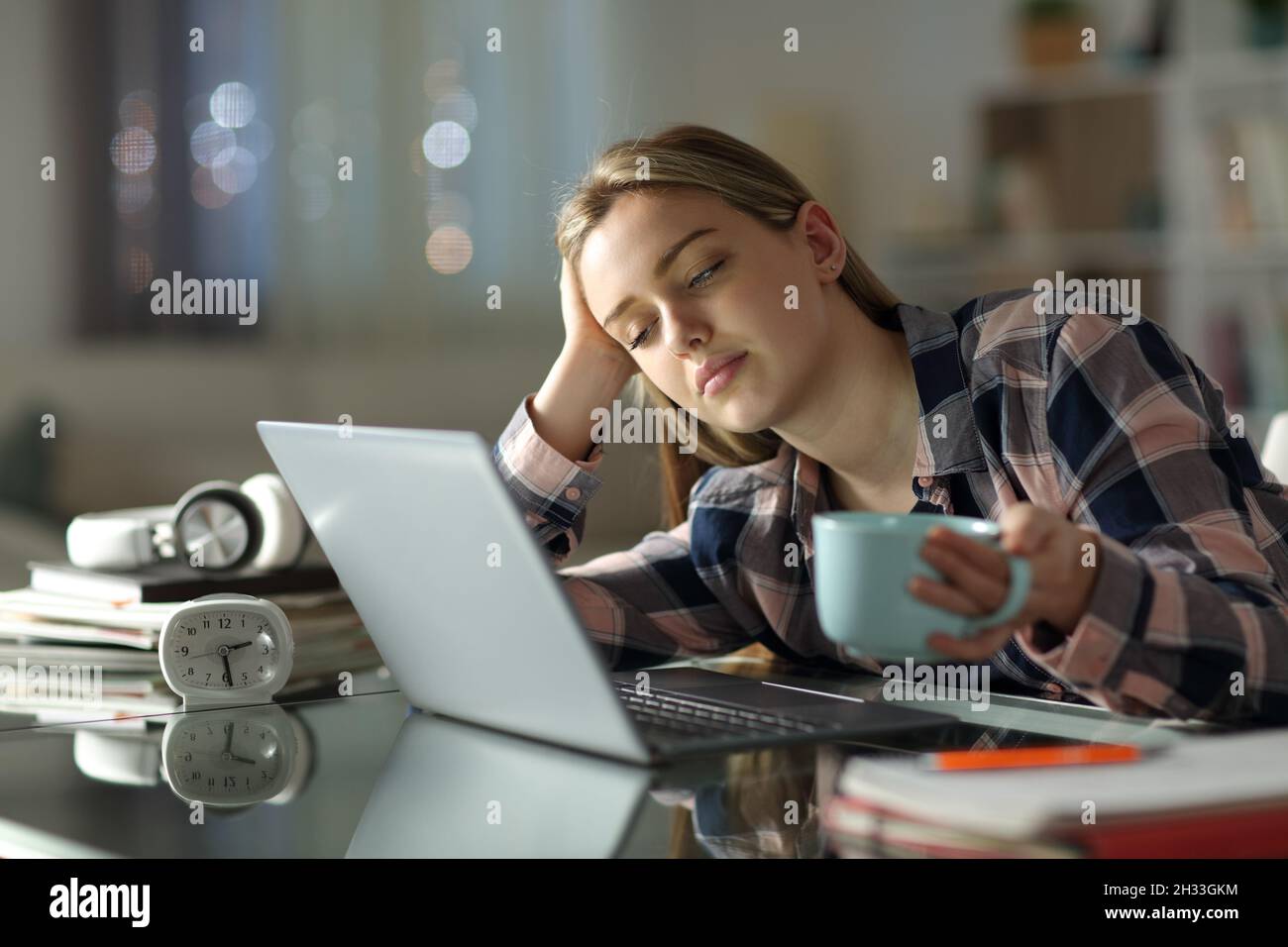 Schlafende müde Student versucht, zu Hause in der Nacht Kaffee trinken zu lernen Stockfoto