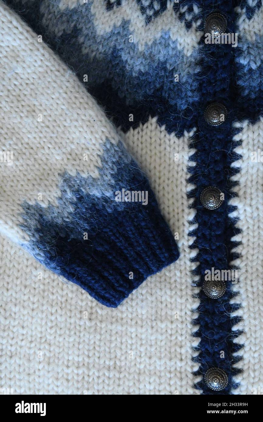 Nahaufnahme des Strickpullovers aus isländischer Schafwolle oder Lopapeysa in Weiß und Blau. Schönes Muster und Strickstruktur. Stockfoto