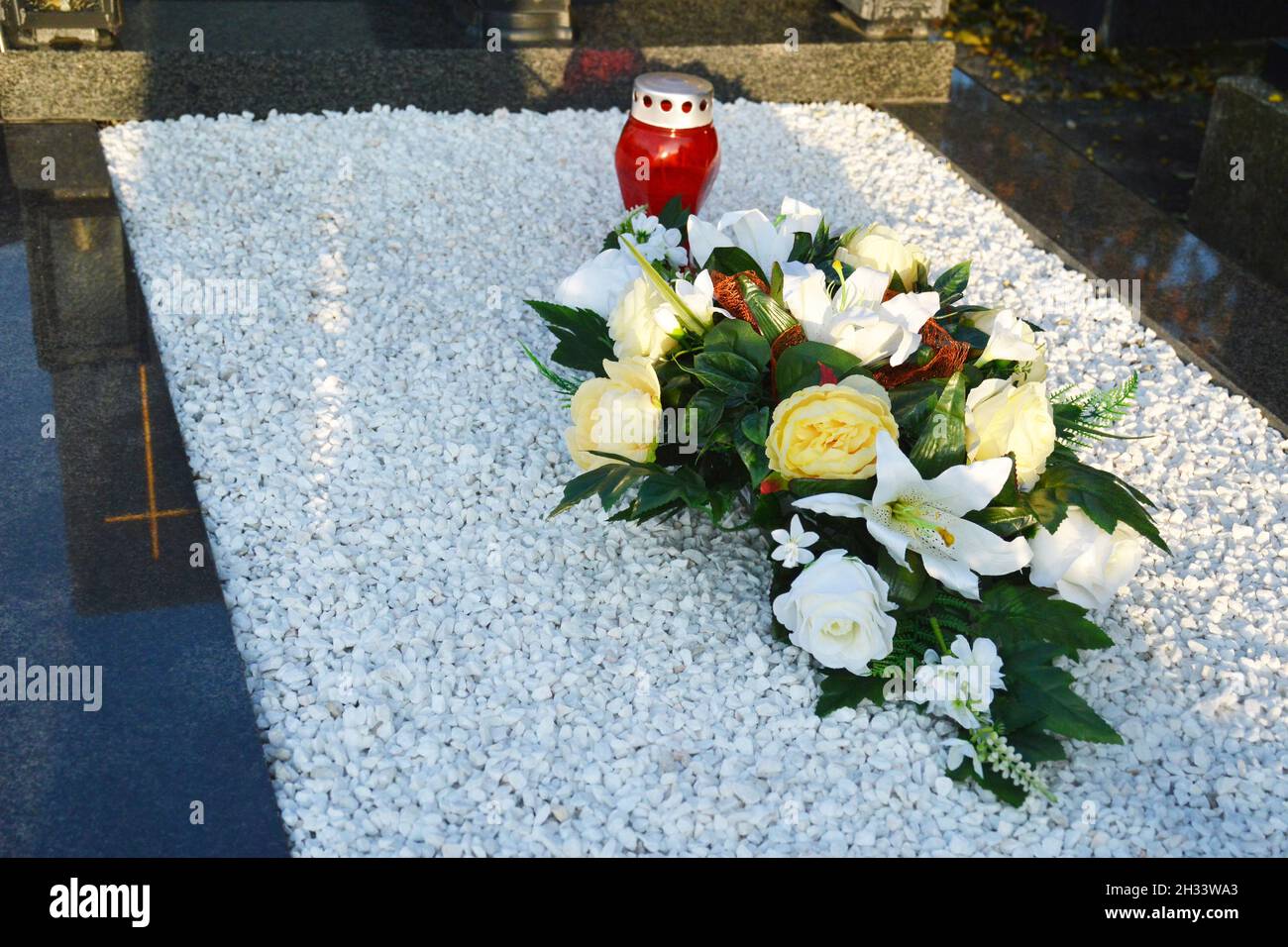 Blumen und Kerze auf dem Grab Stockfoto