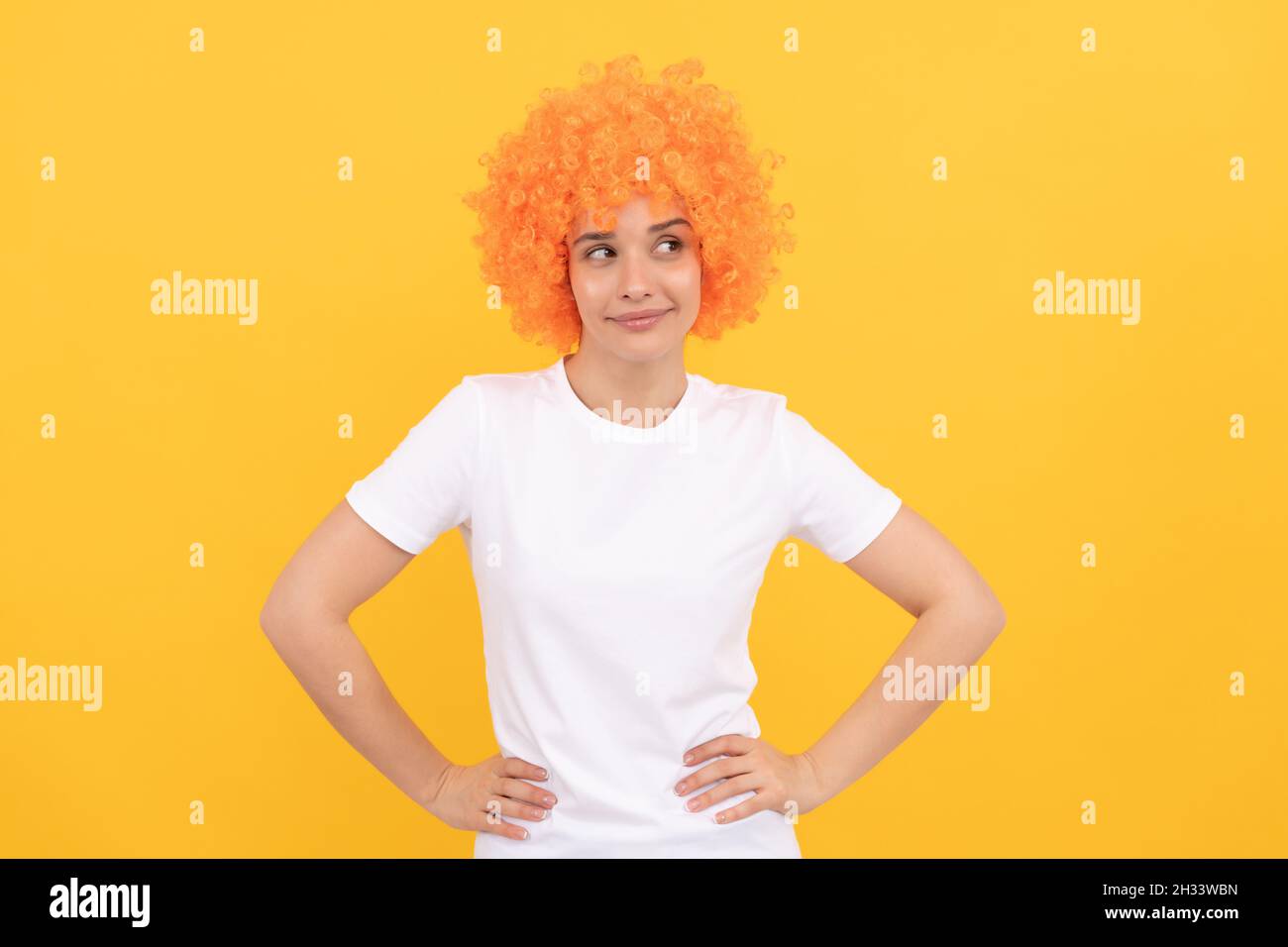Fröhliche Dame tragen Perücke. Frau hat orangefarbene Haare. Als Clown. april Narren Tag. Stockfoto