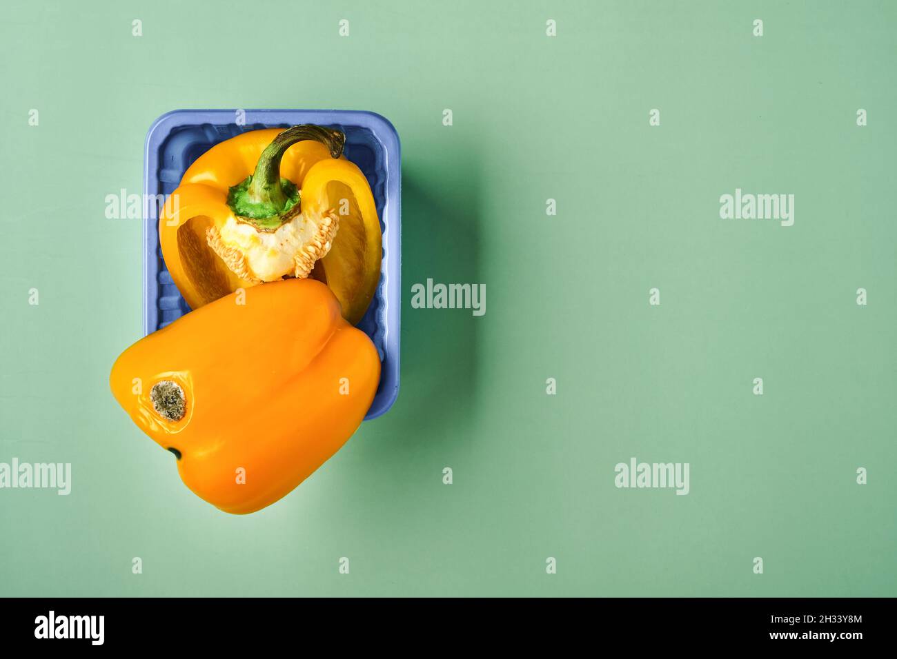 Schimmelige und faltige verfaulte gelbe Paprika. Konzept der ungesunden, zersetzenden, verdorbenen Gemüse. Müllhalde verrottete Lebensmittel auf grünem Hintergrund. Draufsicht. Stockfoto