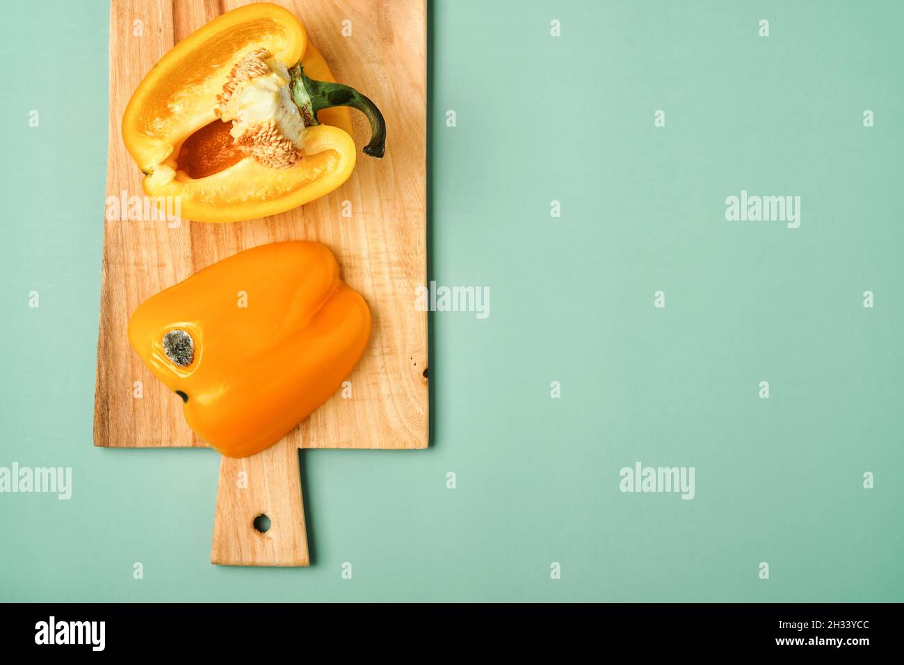 Schimmelige und faltige verfaulte gelbe Paprika. Konzept der ungesunden, zersetzenden, verdorbenen Gemüse. Müllhalde verrottete Lebensmittel auf grünem Hintergrund. Draufsicht. Stockfoto
