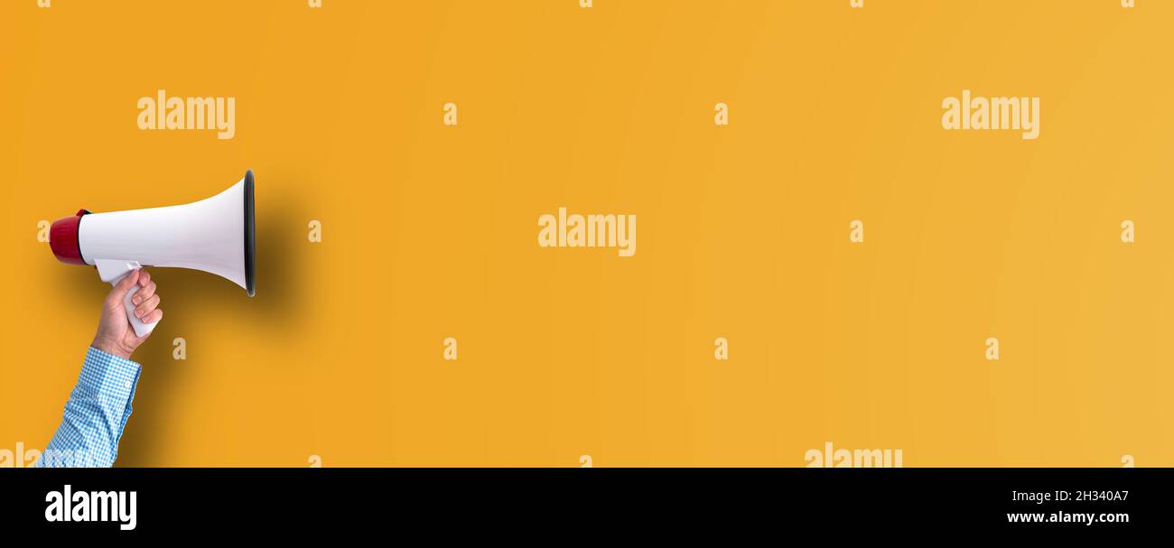 Hand hält Megaphon vor orangenen Hintergrund mit Kopierraum, Marketing-Konzept Stockfoto