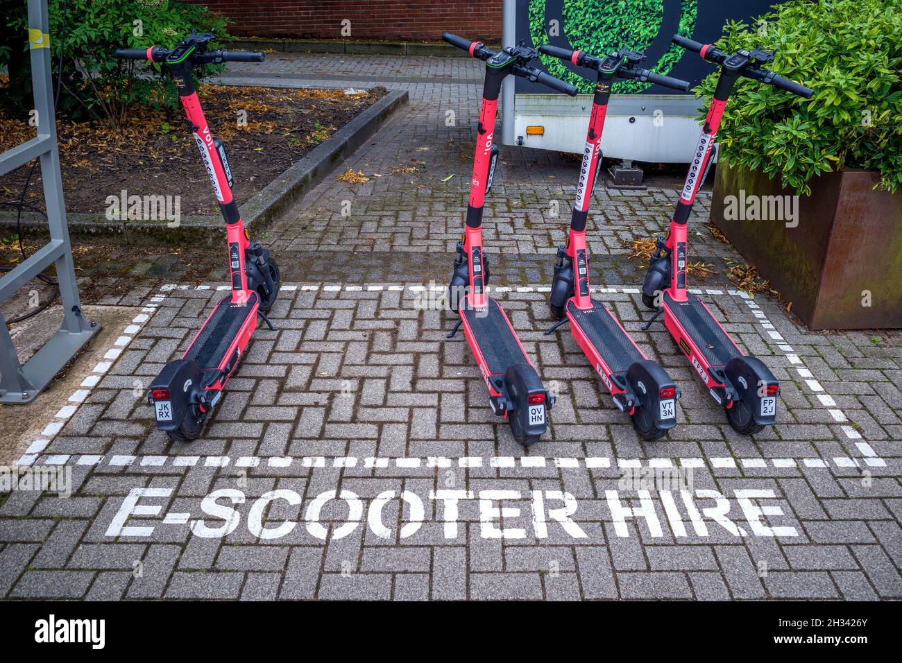 E-Scooter parkten auf einem ausgewiesenen Parkplatz, während sie auf ihre nächste Miete warteten. Stockfoto