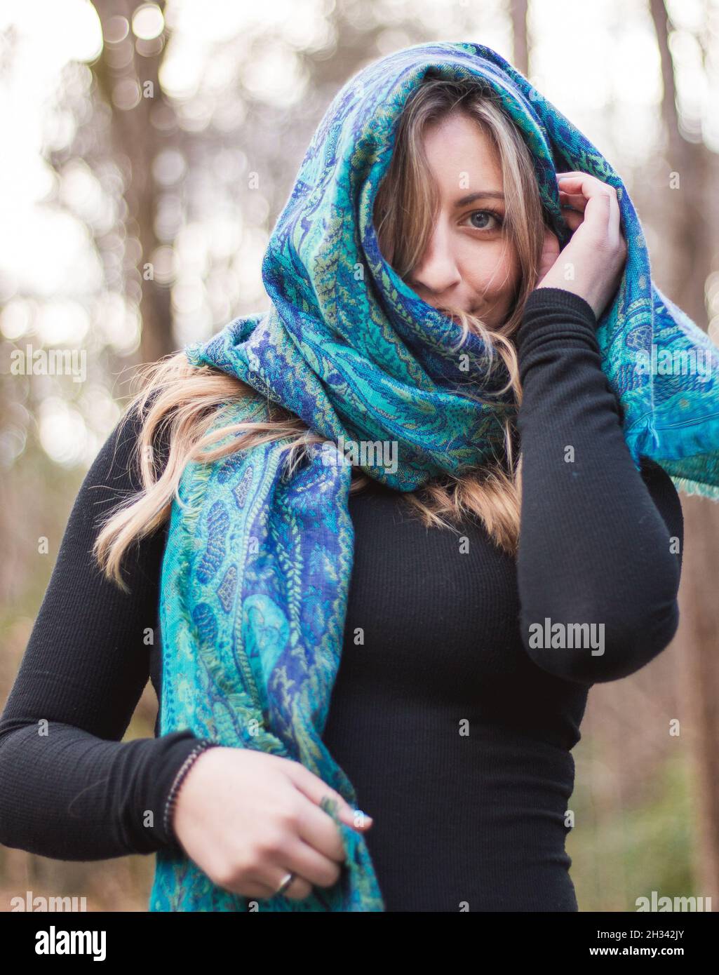 Stilvolle weibliche Modell posiert im Wald genießen den Herbst mit einem blauen Schal und blauen Augen Stockfoto