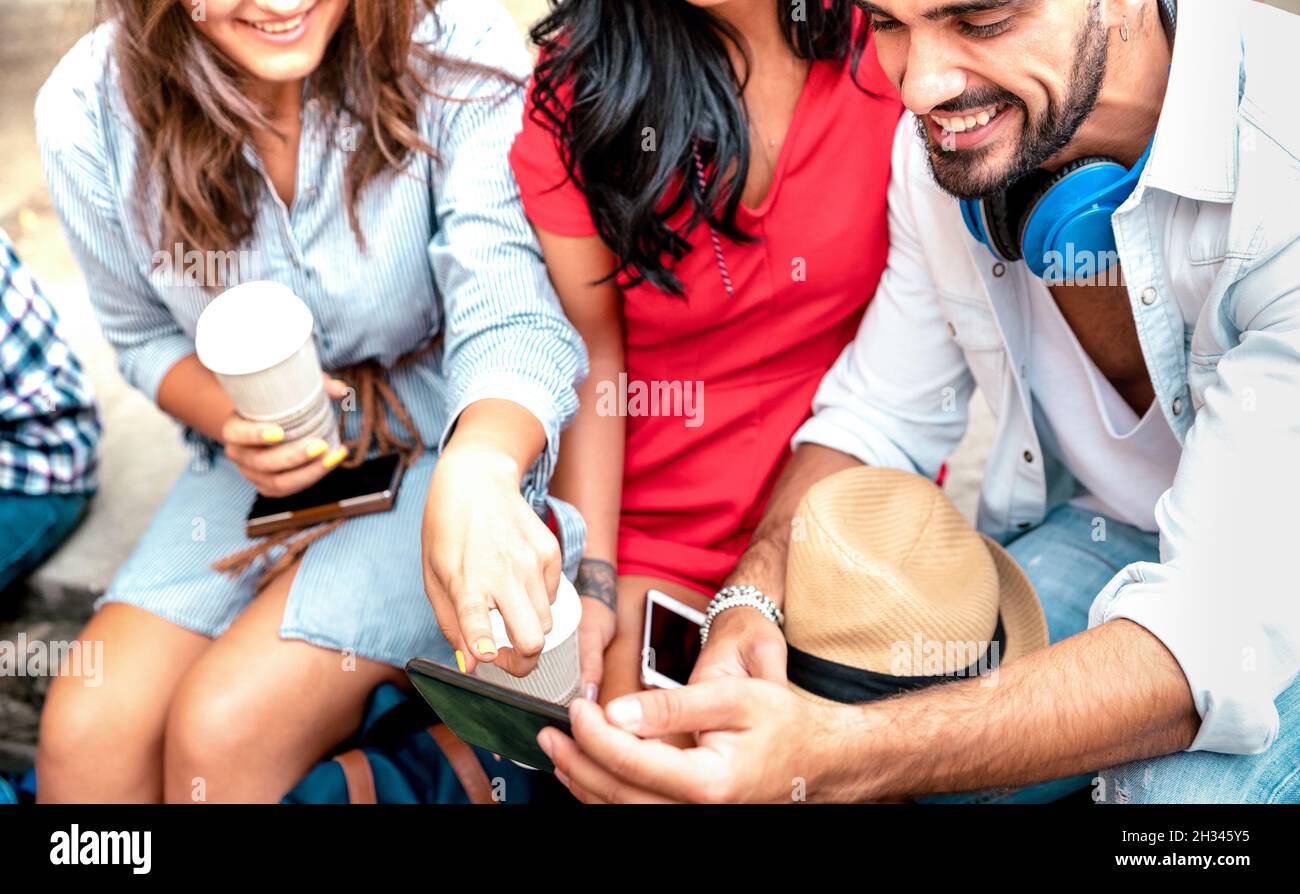Fröhliche Freunde, die gemeinsam Spaß am Outdoor-Standort haben – Jugendliche beeinflussen die Gespräche und den Austausch von Inhalten mit dem Handy Stockfoto