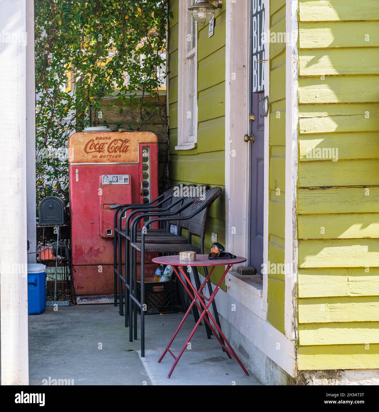 NEW ORLEANS, LA, USA - 23. OKTOBER 2021: Antike Coca Cola Maschine auf der Veranda des Hauses in Mid City Stockfoto