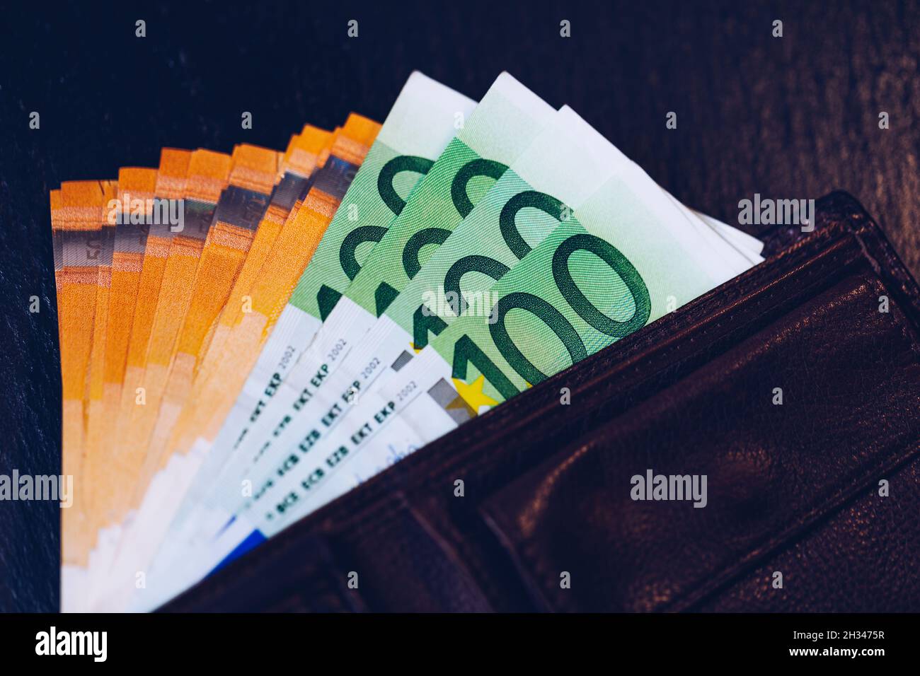 Wallet mit Euro-banknoten. Bargeld in der Brieftasche auf schwarzem Hintergrund. Euro Geld in der Geldbörse. Stockfoto