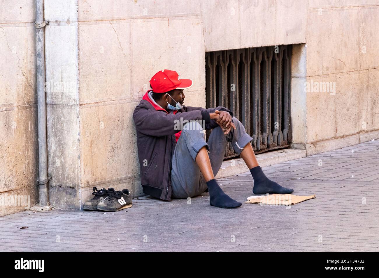 Huelva, Spanien - 24. Oktober 2021: Schwarzer Obdachloser bettelt auf der Straße um Geld Stockfoto
