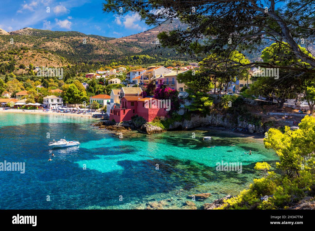Türkisfarbene Bucht im Mittelmeer mit schönen bunten Häusern in Assos Dorf in Kefalonia, Griechenland. Stadt Assos mit bunten Häusern Stockfoto