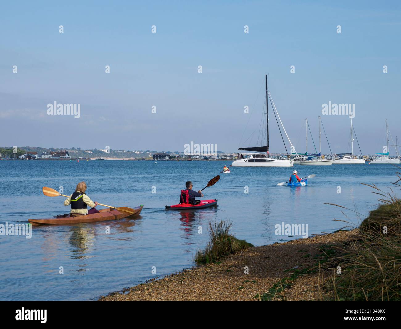 Gruppe von Menschen mittleren Alters, die im Christchurch Harbour, Dorset, Großbritannien, mit dem Kajak fahren Stockfoto