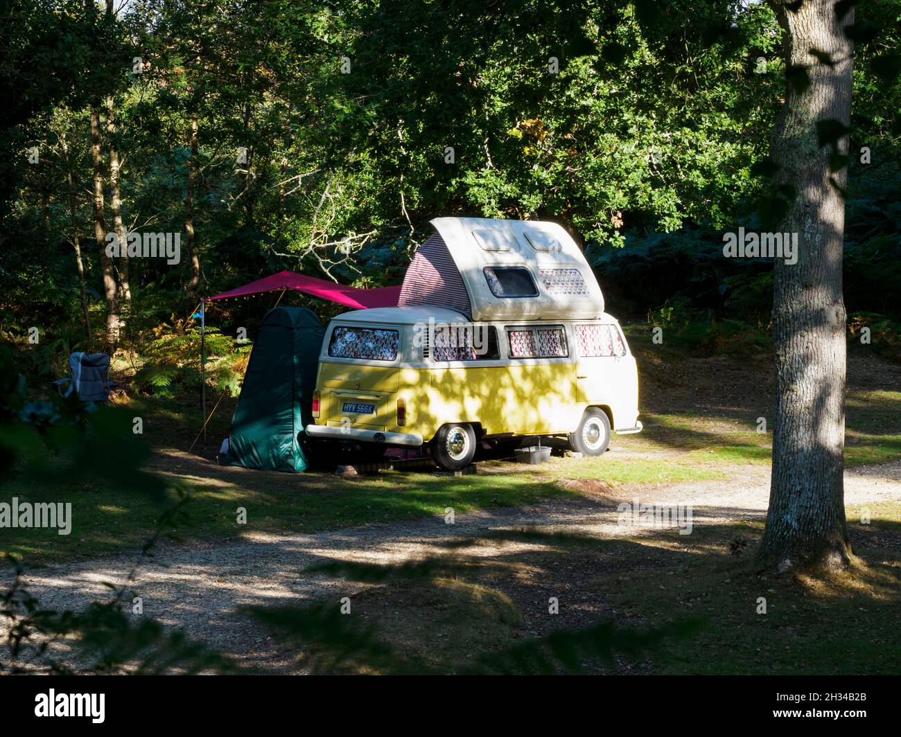 VW Wohnmobil mit seitlichem Höhendach Camping im New Forest, Hampshire, Großbritannien Stockfoto