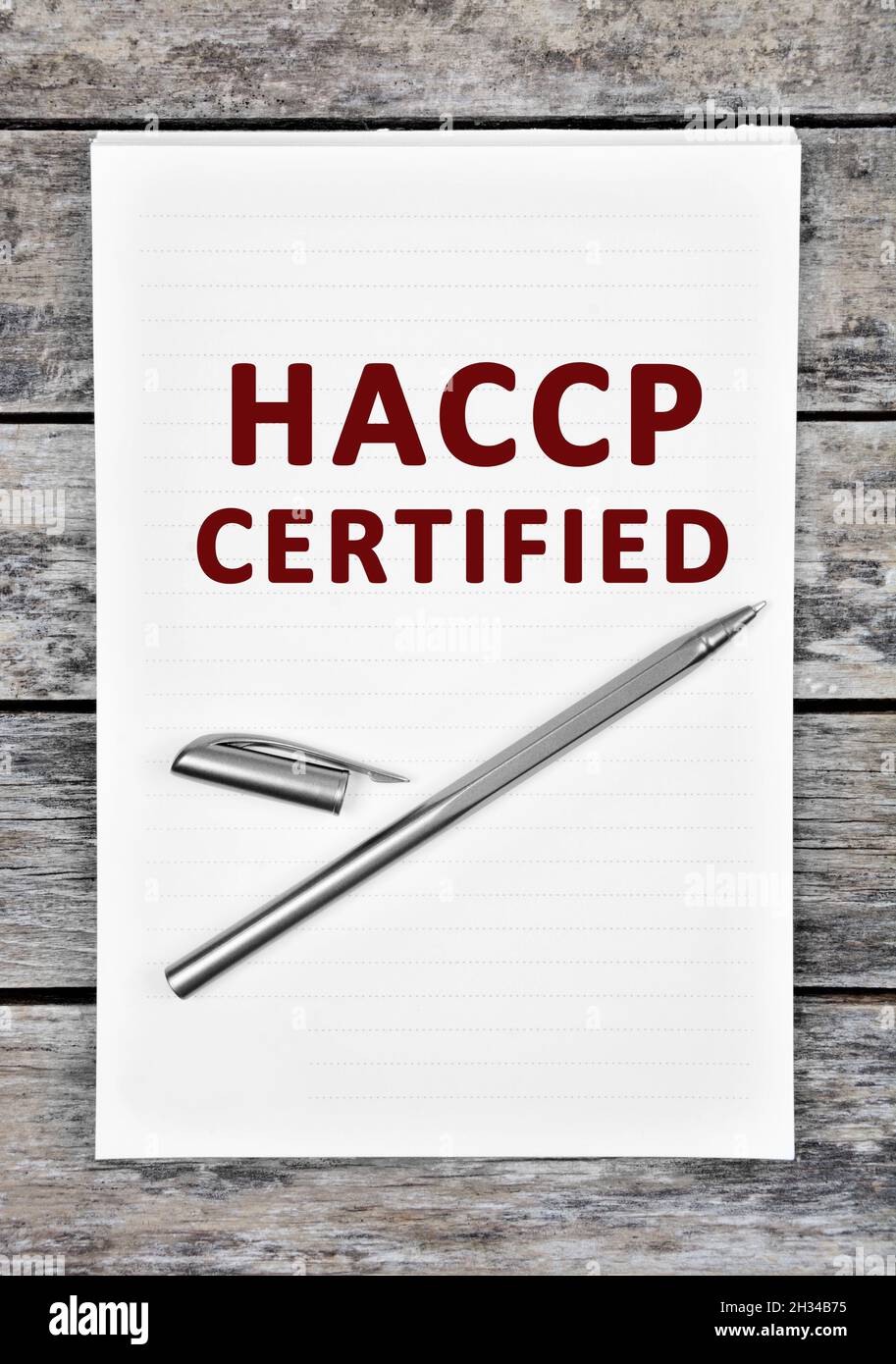 Papier mit HACCP-zertifiziertem Text auf einem Holztisch. Draufsicht Stockfoto