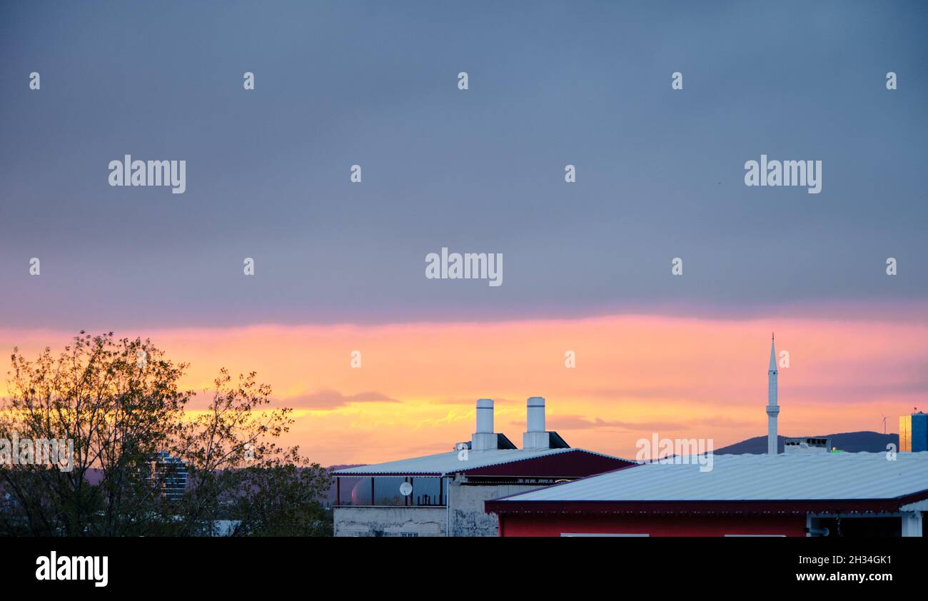 Sonnenuntergang Himmel in bewölktem Tag in Bursa mit Häusern und Dächern mit Minarett einer lokalen Moschee und Radiostationen. Stockfoto