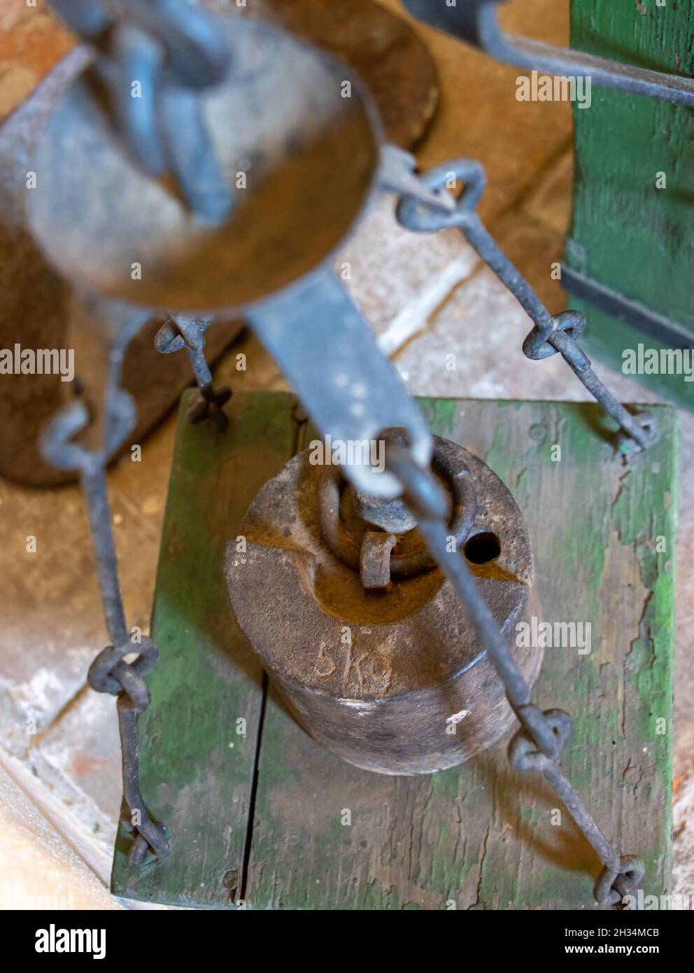 Ein Metallgewicht von 5 Kilogramm auf einer alten Waage Stockfoto