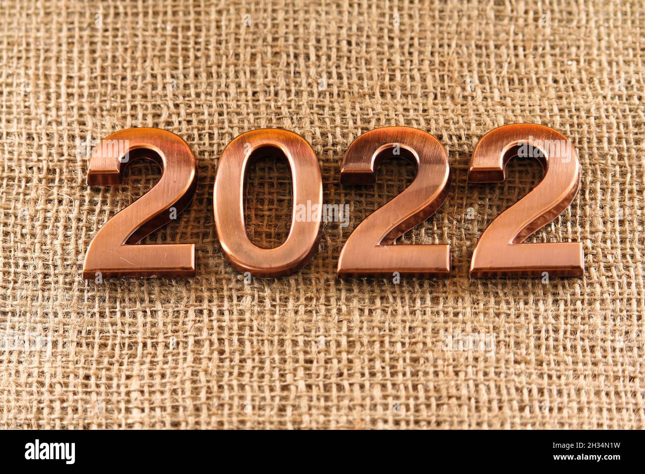Frohes neues Jahr. Die Zahl 2022 auf braunem Hintergrund. Stockfoto