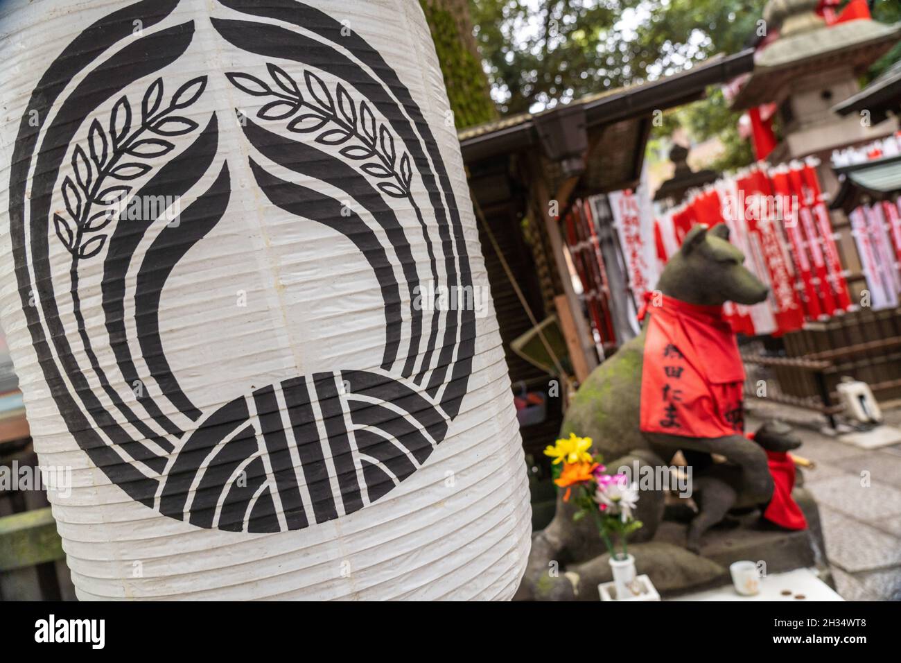 Eine traditionelle Papierlaterne und Statue der Inari Kitsune oder Fuchsgöttin, am Toyokawa Inari Betsuin Tempel in Asakusa, Tokio, Japan. Der buddhistische Tempel ist Teil der Soto Zen Sekte und beherbergt die Gottheit Toyokawa Dakinishinten, aber auch bekannt für die Tausenden von Fuchsstatuen. Stockfoto