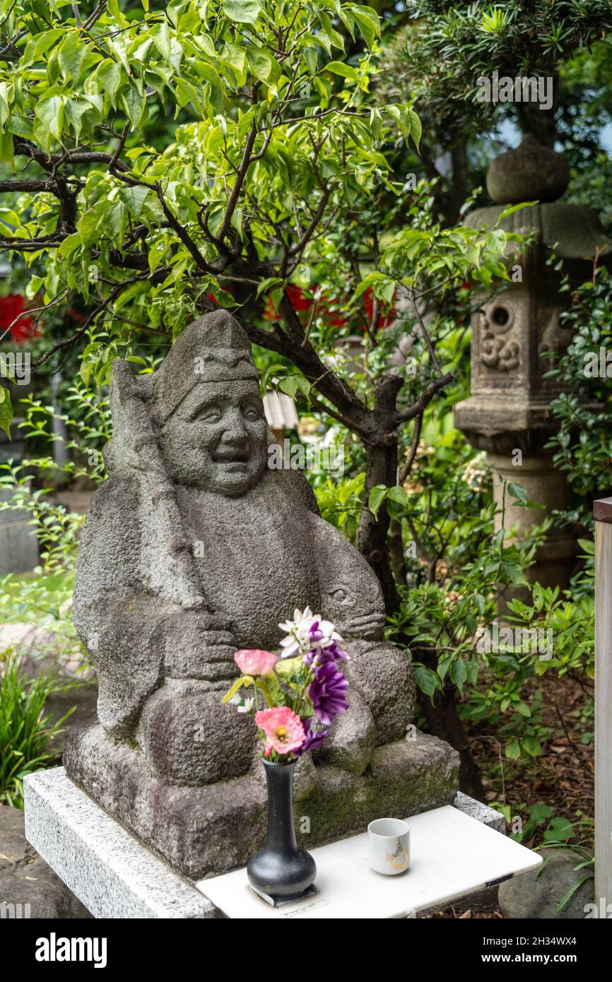 Eine Statue von Ebisu, einem der sieben Glücksgötter, im Toyokawa Inari Betsuin Tempel in Asakusa, Tokio, Japan. Der buddhistische Tempel ist Teil der Soto Zen Sekte und beherbergt die Gottheit Toyokawa Dakinishinten, aber auch bekannt für die Tausenden von Fuchsstatuen. Stockfoto