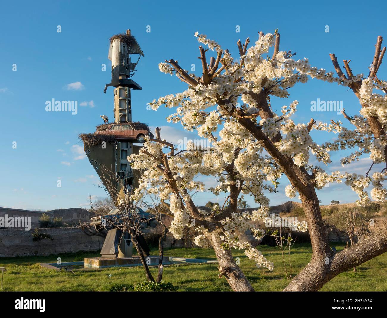 Blüten auf einem Baum stehen im Gegensatz zur Installation Kunstskulptur des verstorbenen deutschen Künstlers Wolf Vostell im Vostell-Malpartida Museum bei Cá Stockfoto