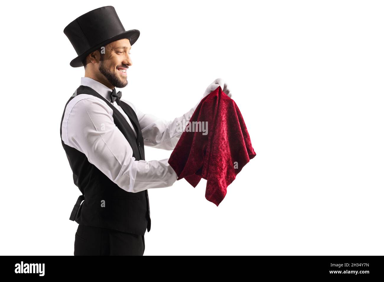 Profilaufnahme eines Zauberers, der einen Trick isoliert auf weißem Hintergrund ausführt Stockfoto