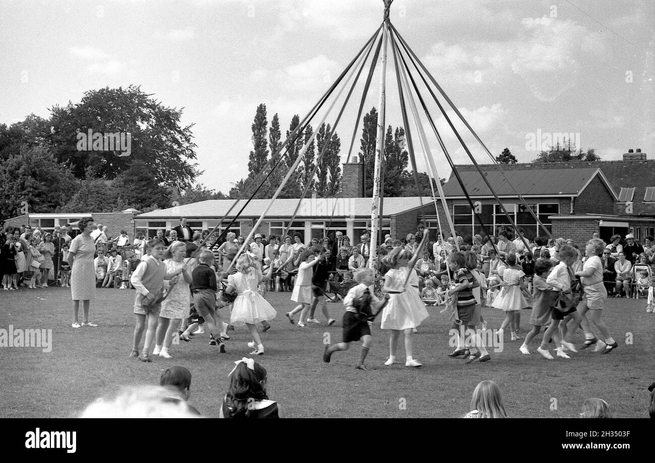 1965 - Grundschulkinder, die während des Schulfeten in Lower Peover, chenshire, um einen Maipfahl tanzen Stockfoto