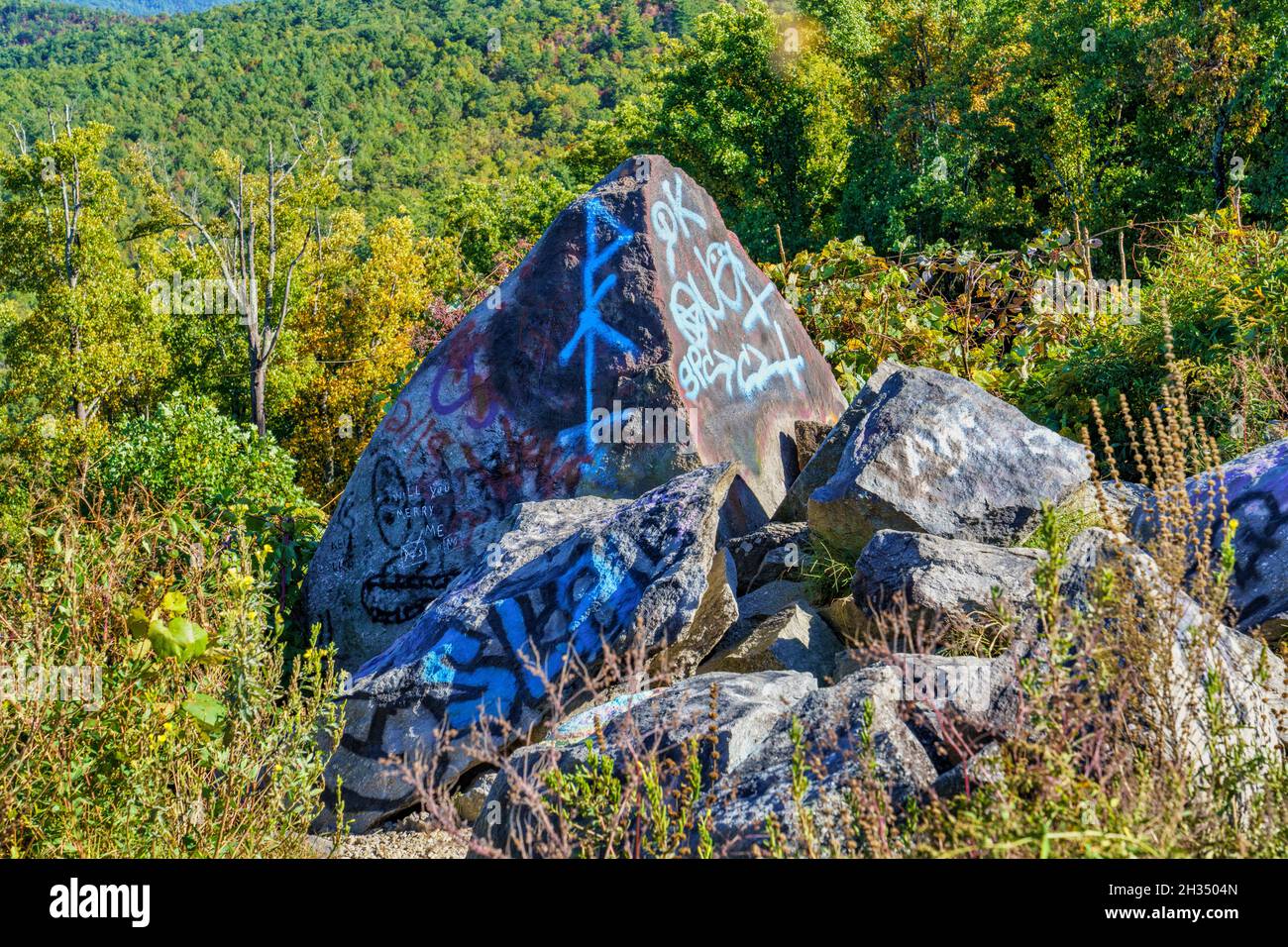 Felsbrocken, die mit Graffiti bedeckt sind, überblicken den Brown Mountain View am Highway 181 in Newland, North Carolina. Stockfoto